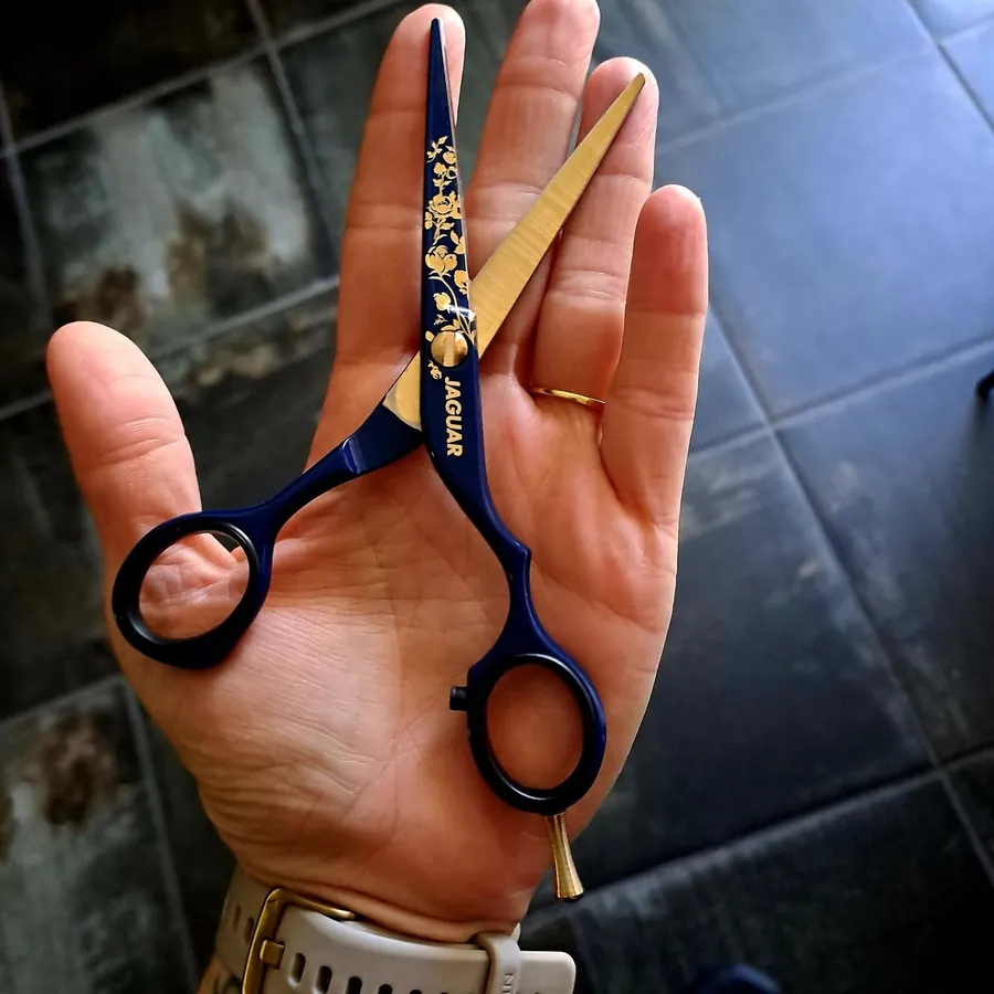 Sandra's navy and gold Jaguar scissors in her hand